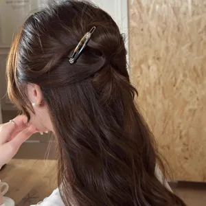 Dettaglio elegante fermaglio per capelli con strass con effetto di usura laterale.