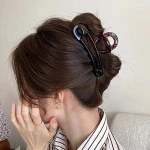 Vue détaillée de la grande pince à cheveux épingle de sûreté maintenant un chignon élégant.
