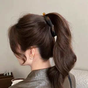Molla per capelli a banana tartaruga per elegante acconciatura di coda e accessorio di stile.