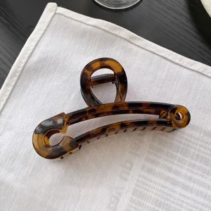 Vue detaillee de la grande pince a cheveux en forme d'epingle de surete en motif ecaille.