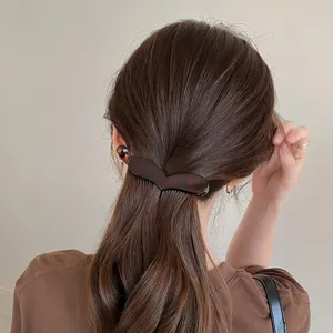 Dettaglio di una molletta per capelli a banana con cuore tartarugato retro indossata dietro.