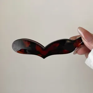Vista dettagliata di un fermaglio per capelli banana tartarugato a cuore per code.