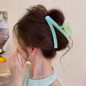 Vue détaillée de la pince à cheveux verte transparente en forme de Z pour élégant chignon.