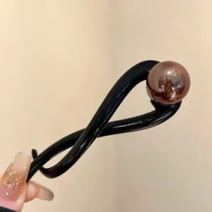 Stylish black twist hair clip featuring a glossy brown pearl bead for chic updos.
