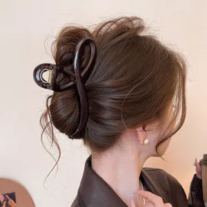 Detailansicht der eleganten braunen Haarklammer mit geschwungenem Design für stylische Frisuren.