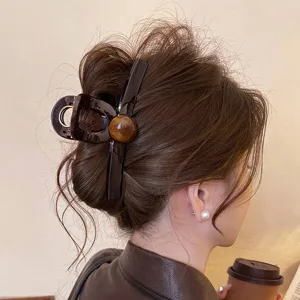 Detailopname van de elegante bruine haarklem gedragen op de achterkant, stijlvol.
