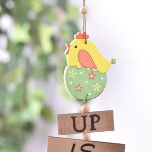 Decoración de Pascua de madera con pollo tierno saliendo del huevo y letreros rústicos.