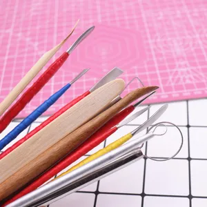 Detail view of clay sculpting tool set featuring various metal and wooden pottery tools.