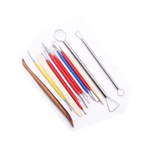 Close-up detail of stainless steel and wooden clay sculpting tools set for pottery and dolls.