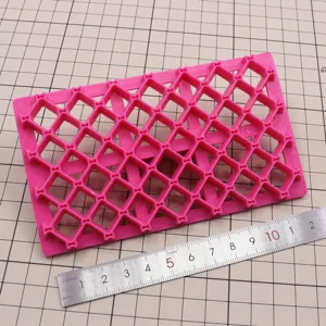 Moule à estamper en plastique rose motif treillis pour travaux en argile et biscuits.