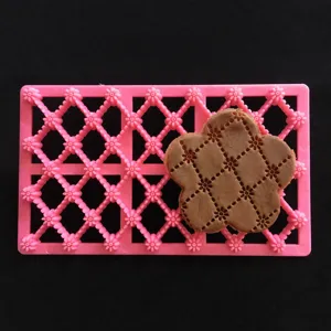 Détail de moule à biscuits en argile rose motif grille fleur, idéal pour la pâte polymère.