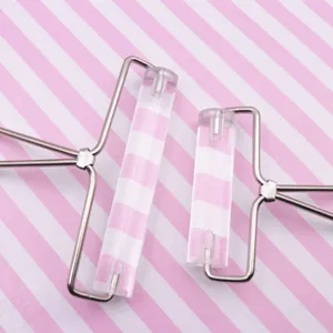 Detalle de rodillo de arcilla acrílica transparente con marco metálico para manualidades DIY.