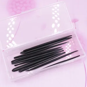 Vue détaillée d'outils de modelage en argile noire rangés dans une boîte en plastique.