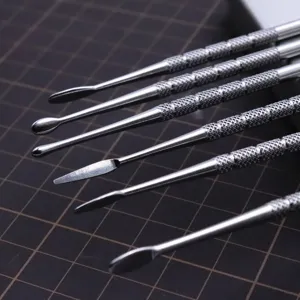 Detailaufnahme von Tonwerkzeugen aus Edelstahl mit strukturierten Griffen und Spitzen.