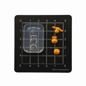 Silicone mold for mini dog and frog clay cookies, detailed view on measuring board.