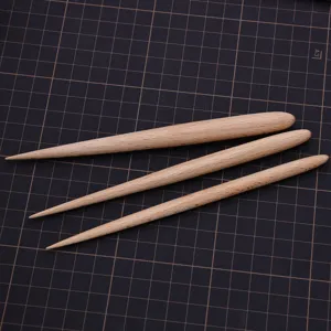 Primer plano de utensilios de modelado en madera, set de tres piezas con puntas y extremos redondos.