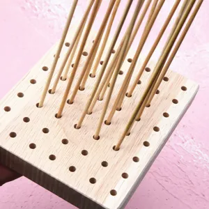 Solid wood perforated base detail view with bamboo sticks for clay figure DIY and doll drying.