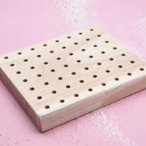 Solid wood perforated base detail for DIY clay figurines and drying crafts, natural grain.
