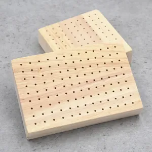 Thickened wooden base with drilled holes for polymer clay doll wire armature support.