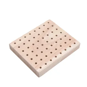 Wooden peg board detail showing drilled holes for clay figurine drying and crafting display.