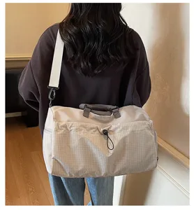 Vue détaillée du grand sac de voyage avec poche en filet à l'avant et bandoulière.