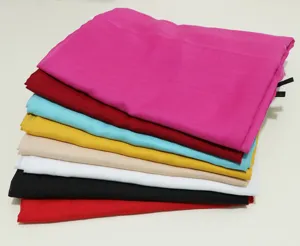 Detail view showing a neat stack of colorful solid lightweight scarves, perfect for beach use.