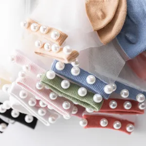 Primer plano detallado de calcetines transparentes de cristal con puños de perlas.