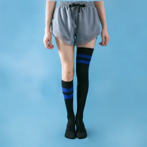 Detail view of women's athletic compression socks in black with blue stripes for running fitness.