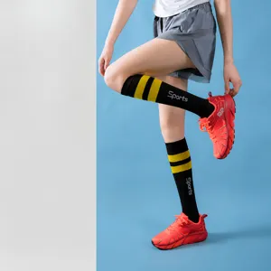 Close-up of women's sports compression calf socks with yellow stripes and fitted design.