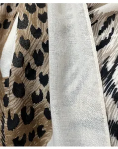 Close-up detail of luxurious vintage leopard print women's lightweight summer scarf texture.