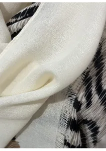 Close-up detail of luxury leopard print women's summer scarf with fringe edge fashion.
