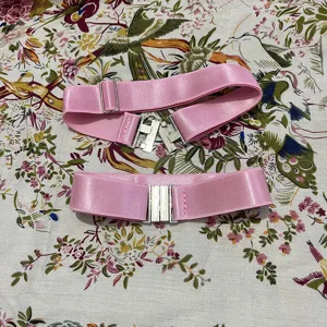 Pink over-the-knee sock anti-slip elastic strap detail showing the metal buckle design.