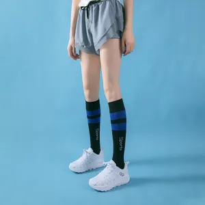 Close-up view of black compression sports socks featuring blue stripes and white letter print.