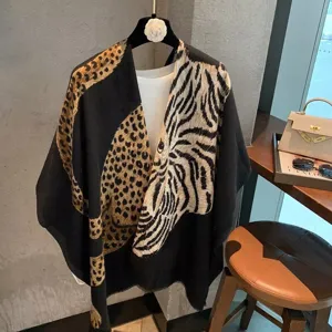Close-up detail of the asymmetric animal print shawl, featuring bold leopard and tiger patterns.