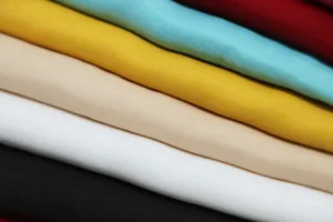 Close up view of multi colored soft cotton fabric texture, detailed view of folded scarves.