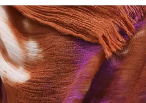 Close-up detail shot of crinkled tie-dye scarf fabric with elegant color transition.