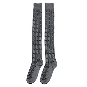 Detailed view of grey cable-knit over-the-knee socks, showing the classic twisted pattern.