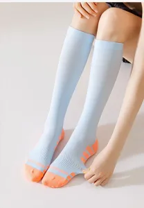 Detailed view of light blue calf compression sports socks with orange toe and heel design.