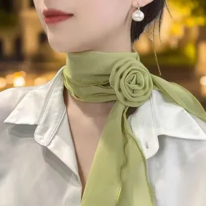 Close-up detail of the elegant light green chiffon neck scarf with a 3d rose flower design.