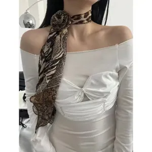Close-up of leopard print chiffon scarf, elegant rose flower neck accessory for women.