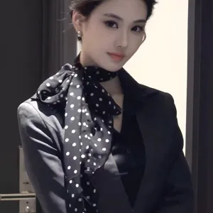 Detailed view of women's black and white polka dot chiffon scarf, lightweight and elegant.