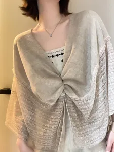 Detailansicht eines stylischen leinenfarbigen Spitzenschals, leichtes modisches Sommer-Strandtuch.