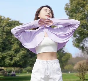Detail view of a lightweight purple sun protection bolero, outdoor park setting, breathable.