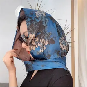 Vista dettagliata dell'elegante foulard in seta floreale blu come copricapo parasole.