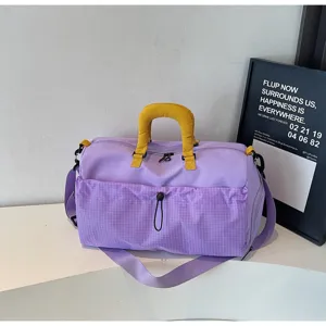 Vue détaillée du grand sac de voyage violet avec poignées jaunes et poche à grille.