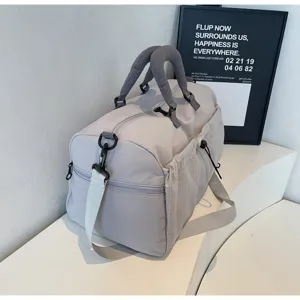 Grand sac de voyage gris avec poche latérale en maille, sac de sport et de fitness résistant.