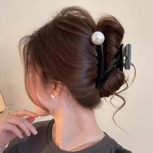 Detailansicht einer eleganten schwarzen Haarklammer mit großer Perle für das tägliche Styling.