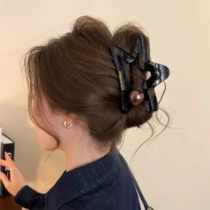 Grande molletta per capelli a stella cava con perla marrone, elegante accessorio per styling.