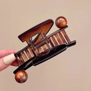 Nahaufnahme der kreativen klavierförmigen Haarklammer in glänzendem braunen Schildpatt-Design.