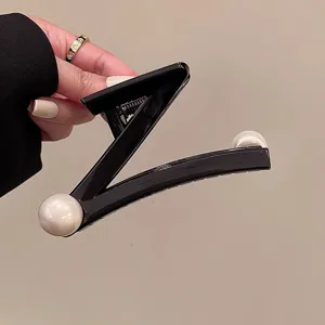 Nahaufnahme Detailansicht der schwarzen geometrischen Perlen Haarkralle mit feinem Dekor.